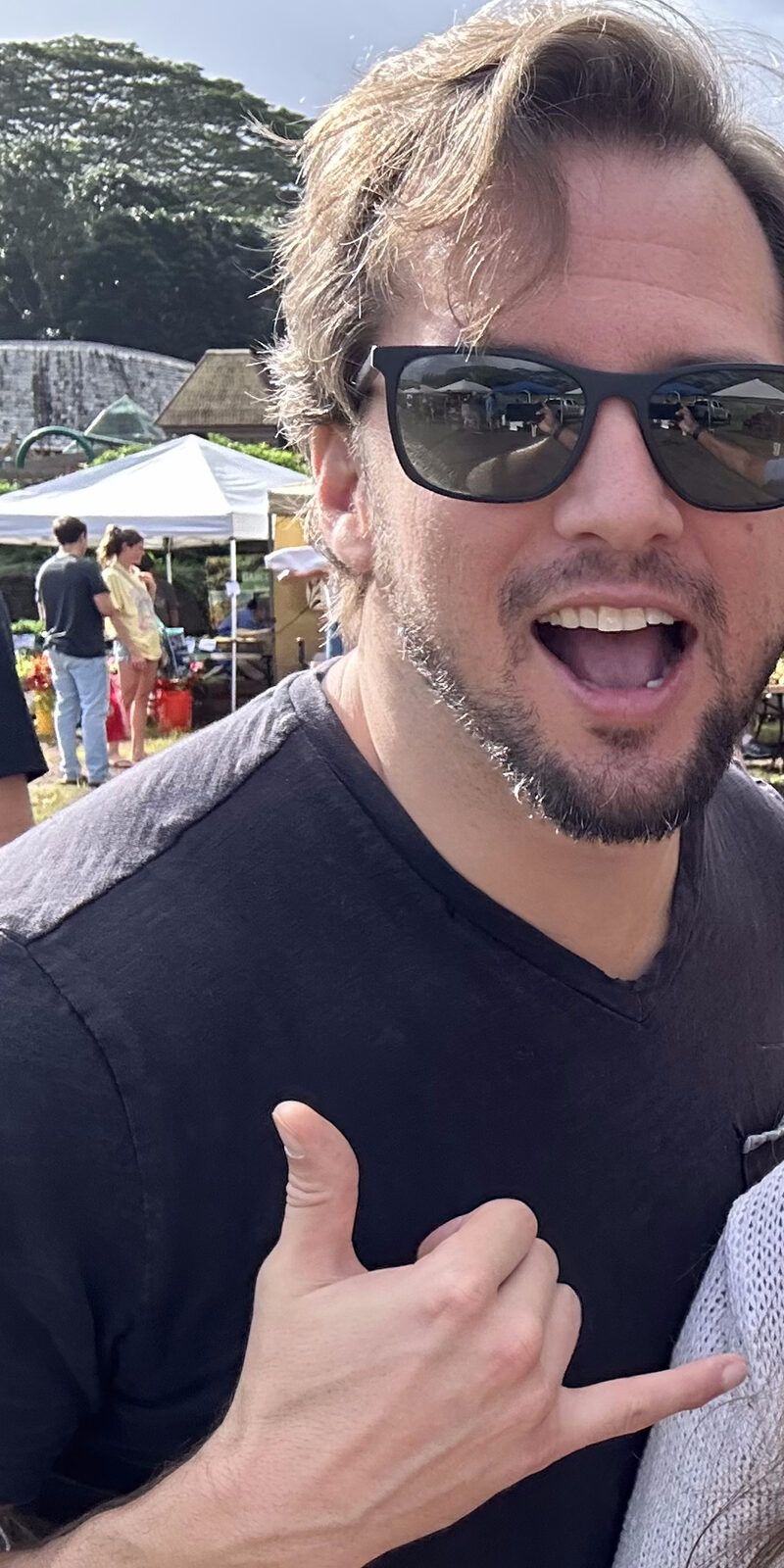 Greg Horn at a Kauaʻi farmers market, throwing a shaka